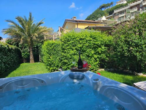 a hot tub in a yard with a bottle of wine at La Rocca Maison de Charme in Moneglia