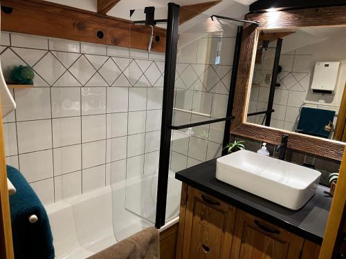 une salle de bain avec un lavabo blanc et une douche dans l'établissement Appartement Schuss II vue montagne au pied des pistes, à Flumet