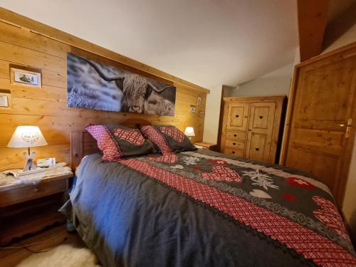 une chambre avec un lit et un mur en bois dans l'établissement Appartement Schuss II vue montagne au pied des pistes, à Flumet