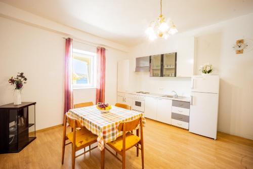 eine Küche mit einem Tisch und Stühlen im Zimmer in der Unterkunft Apartment Coral in Metajna