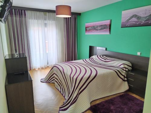 1 dormitorio con 1 cama con pared verde en Apartamento El Alfar, en Talavera de la Reina