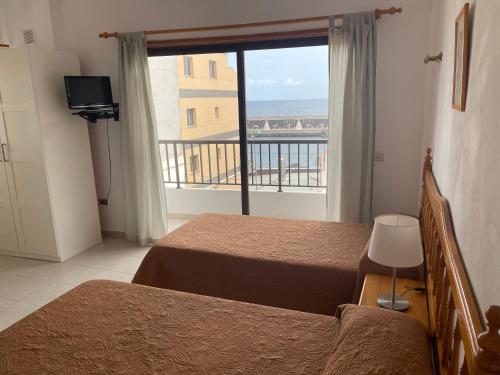 1 dormitorio con 2 camas y vistas al océano en Apartamentos Tanajara, en La Restinga
