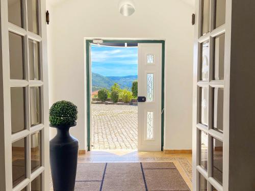 a vase sitting in front of a door with a view at Vinhais Hotel in Vinhais