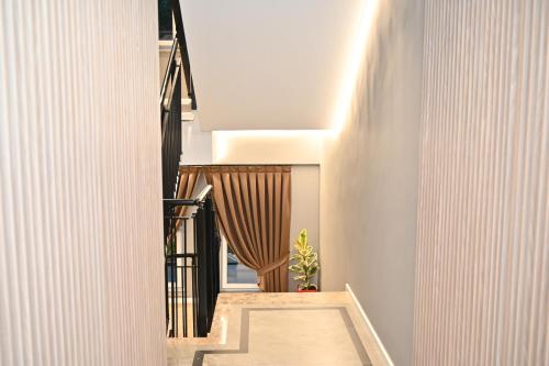 a hallway of a house with white walls and a staircase at Hotel Vino in Durrës