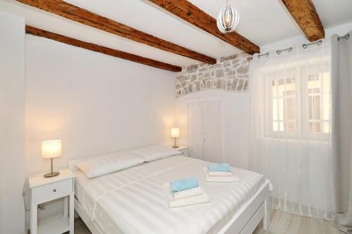 ムルテルにあるStone House apartments in the center of Murter townの白いベッドと窓のある白い寝室