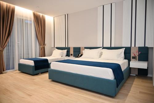 Dos camas en una habitación de hotel con dos en Hotel Vino en Durrës