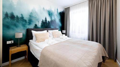 シュクラルスカ・ポレンバにあるApartamenty Good Time - Stone Hill IVのベッドルーム1室(壁に絵画が描かれた大型ベッド1台付)