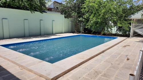a swimming pool with blue water in a backyard at Family holiday home. in Qusar