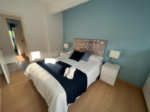 1 dormitorio con 1 cama grande y 2 toallas. en casa culleredo, en A Coruña