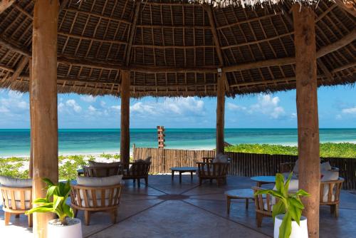 a restaurant with the beach in the background at Amani Boutique Hotel - Small Luxury Hotels of the World in Paje