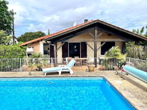 une maison avec une piscine devant une maison dans l'établissement Villa Amandiers, à Andernos-les-Bains