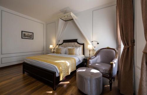 a hotel room with a bed and a chair at Le Thatluang D'oR Boutique Hotel in Vientiane