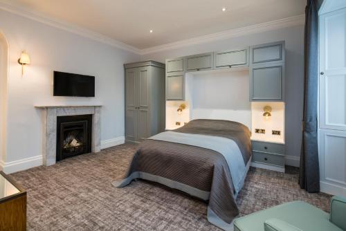 a bedroom with a bed and a fireplace at Lilleshall House & Gardens and Lilleshall National Sports Centre in Telford