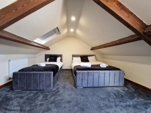 two beds in a room with a roof at Hidden Beauty! 5 Bedroom House near town centre with Bike Store in Merthyr Tydfil