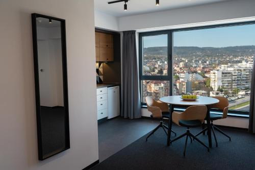 a kitchen with a table and chairs and a large window at Hotel Campus 90 - Free Parking in Varna City