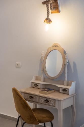 a dressing table with a mirror and a chair at Sun Angelos Oia - Luxury Cave Suites in Oia