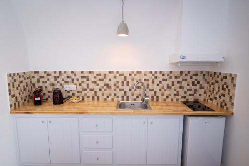 a kitchen with a sink and a counter top at Sun Angelos Oia - Luxury Cave Suites in Oia