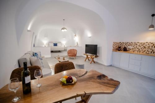 a living room with a table and wine glasses at Sun Angelos Oia - Luxury Cave Suites in Oia