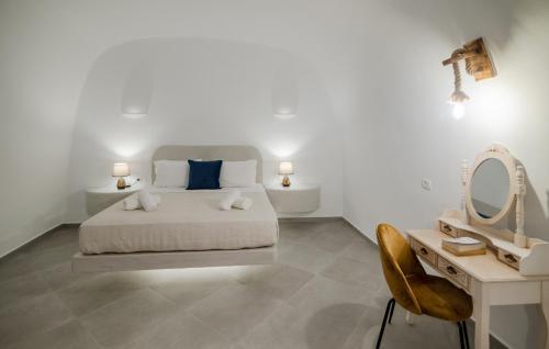 a bedroom with a bed and a vanity and a mirror at Sun Angelos Oia - Luxury Cave Suites in Oia