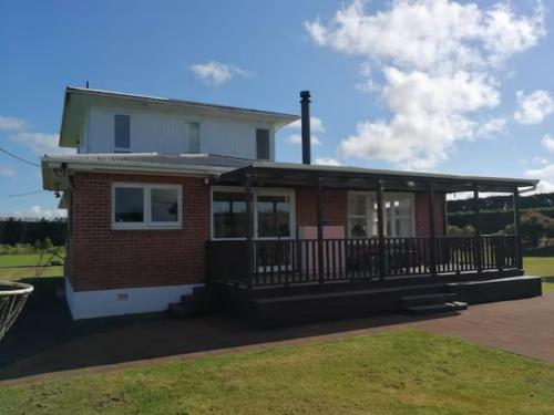 a house with a porch and a balcony at Besties West Auckland in Kumeu