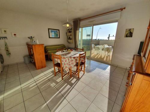 une salle à manger avec une table et un balcon dans l'établissement Appartement T2/Cabine en RDC, 4 Couchages, Terrasse, Parking Privé, à 50m de l'Océan - St-Hilaire-de-Riez - FR-1-224C-50, à Saint-Hilaire-de-Riez