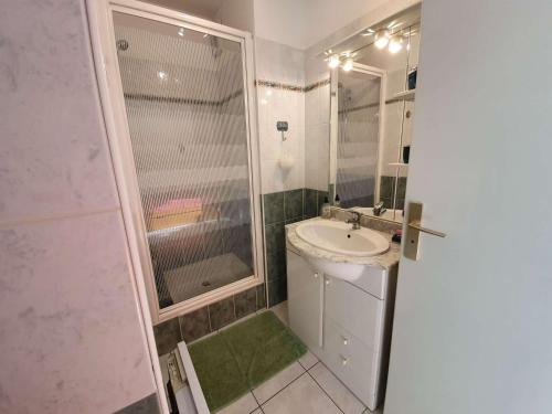 une salle de bain blanche avec un lavabo et une douche dans l'établissement Appartement T2/Cabine en RDC, 4 Couchages, Terrasse, Parking Privé, à 50m de l'Océan - St-Hilaire-de-Riez - FR-1-224C-50, à Saint-Hilaire-de-Riez