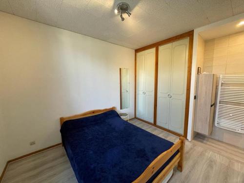 ein Schlafzimmer mit einem Bett mit einer blauen Decke in der Unterkunft Appartement Capbreton, 2 pièces, 4 personnes - FR-1-413-111 in Capbreton