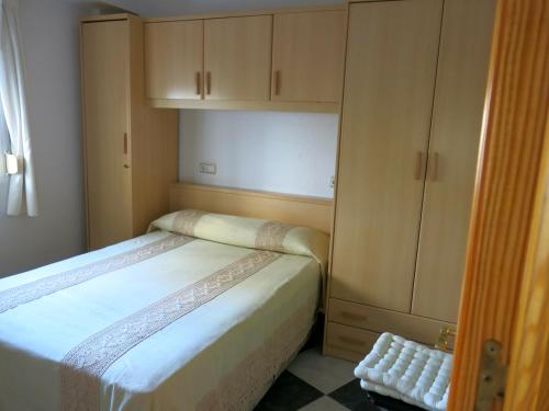a small bedroom with a bed and a cabinet at Oasis junto al mar in Torre del Mar