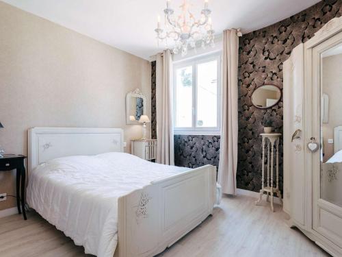 - une chambre avec un lit blanc et un lustre dans l'établissement Carnac Plage - Superbe T2 rénové, 60m², Wifi, à 50m de la Grande Plage, 4 pers. - FR-1-477-41, à Carnac