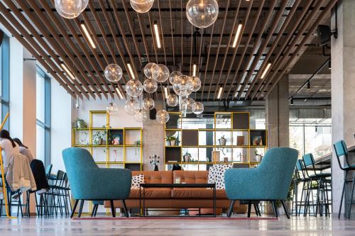 a lobby with a brown couch and blue chairs at Hotel Campus 90 - Free Parking in Varna City