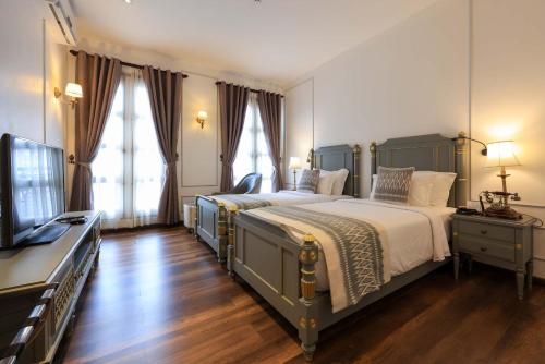 sypialnia z dużym łóżkiem i telewizorem w obiekcie Le Thatluang D'oR Boutique Hotel w mieście Wientian