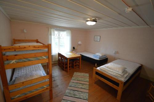 a bedroom with two bunk beds and a window at Statarlängan Hörnefors in Hörnefors