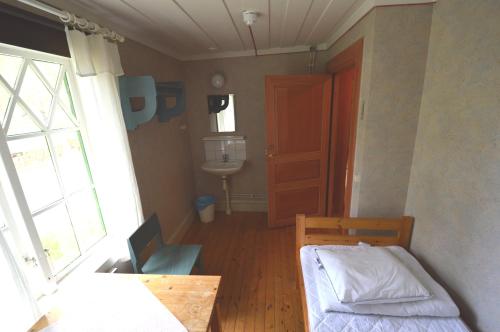 Habitación pequeña con cama y lavamanos en Statarlängan Hörnefors, en Hörnefors