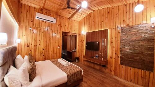 a bedroom with wooden walls and a bed in a room at Qcent Woods Resort & Spa, Rishikesh in Rishīkesh