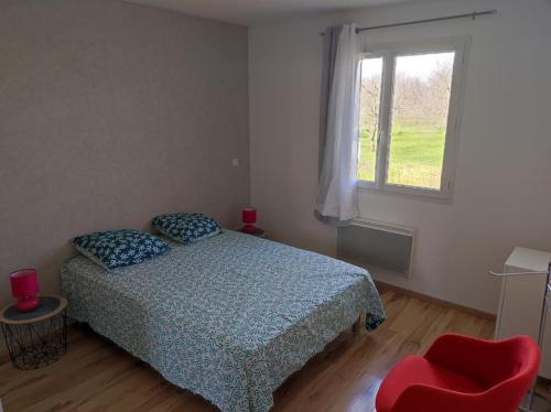 ein Schlafzimmer mit einem Bett, einem Fenster und einem roten Stuhl in der Unterkunft Appartement terrasse du Vercors piscine et spa in Saint-Marcellin