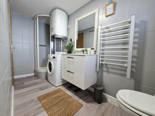 a bathroom with a sink and a washing machine at Promenada Apartment in Srima