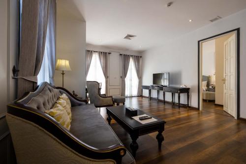 a living room with a couch and a table at Le Thatluang D'oR Boutique Hotel in Vientiane