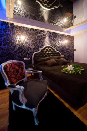 a bedroom with a bed and a chair and lights at HOTEL PRIVE in Skaramangás