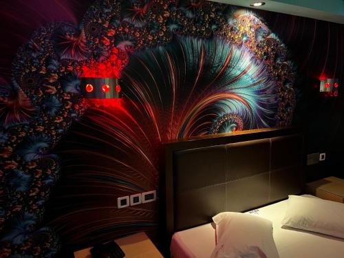 a bedroom with a wall with a painting of a flower mural at HOTEL PRIVE in Skaramangás