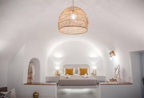 a bedroom with a bed and a pendant light at Sun Angelos Oia - Luxury Cave Suites in Oia