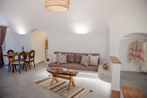 a living room with a couch and a table at Sun Angelos Oia - Luxury Cave Suites in Oia
