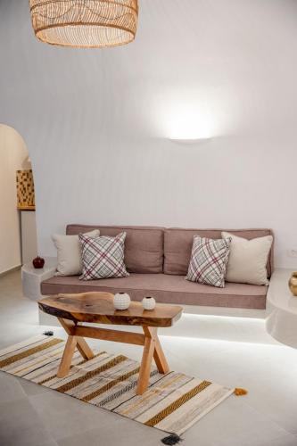 a living room with a couch and a coffee table at Sun Angelos Oia - Luxury Cave Suites in Oia