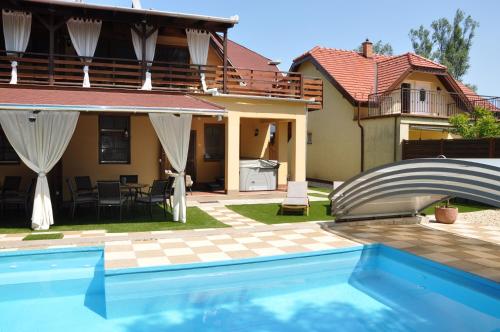 uma piscina em frente a uma casa em Garden Villa Zsóry em Mezőkövesd