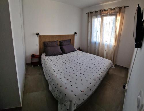 une chambre avec un grand lit avec une fenêtre dans l'établissement Maison U nidu à 500m de la mer, à Cervione