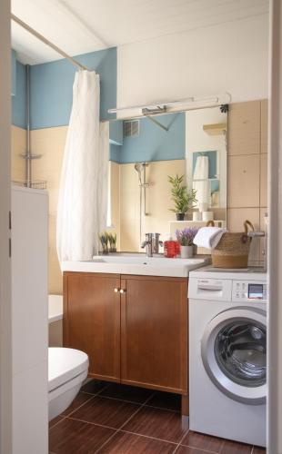 une salle de bain avec une machine à laver et un lavabo dans l'établissement L'îlot - Tout confort, à Strasbourg