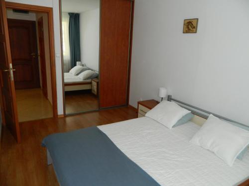 ein Schlafzimmer mit einem großen Bett und einem Spiegel in der Unterkunft Blue Mare - Duży balkon in Łukęcin