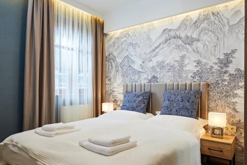 a bedroom with a large bed with towels on it at Garden Villa Zsóry in Mezőkövesd