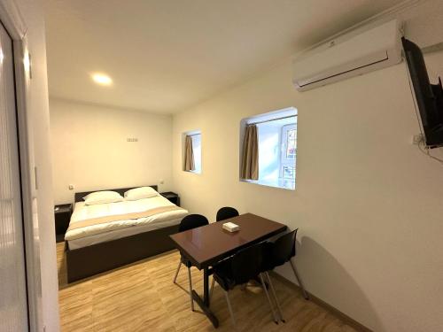 une chambre avec un lit et une table avec des chaises dans l'établissement Apartments on Buzand street, à Erevan