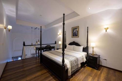a bedroom with a bed and a desk in it at Le Thatluang D'oR Boutique Hotel in Vientiane