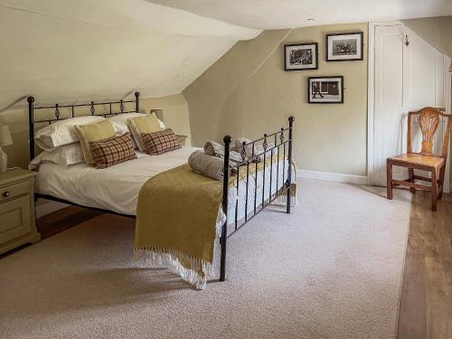 a bedroom with a large bed and a chair at Chipley Escapes - Otters Holt in Milverton